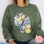 Military Green Oyster Shell sweatshirt with watercolor oysters and lemon wedges, coastal aesthetic pullover, Gildan 18000 DTG, perfect for fisherman aesthetic and ocean lifestyle.