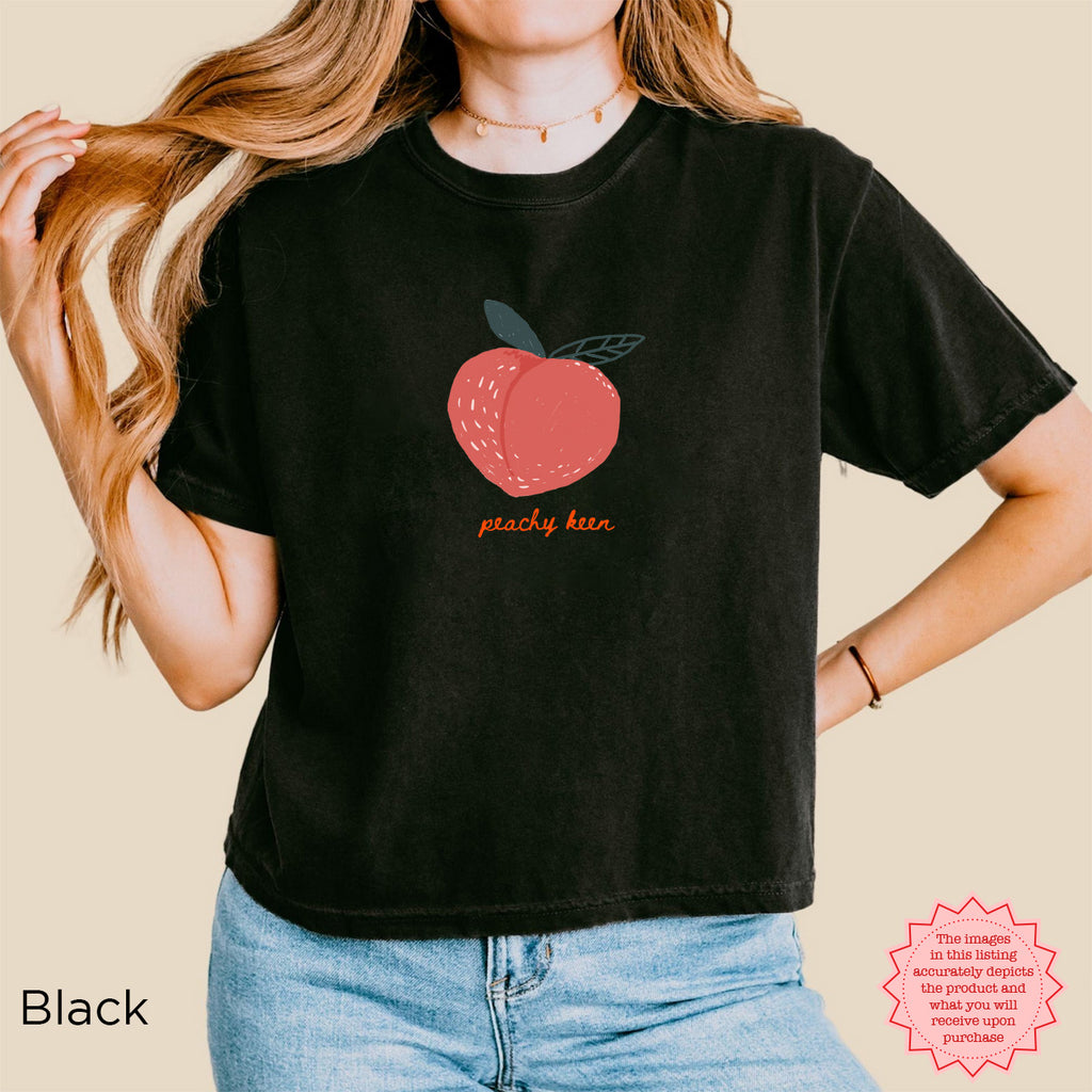 Peachy Keen Crop Shirt in Black with a cute peach graphic on the chest, ideal for a trendy and fun summer look.
