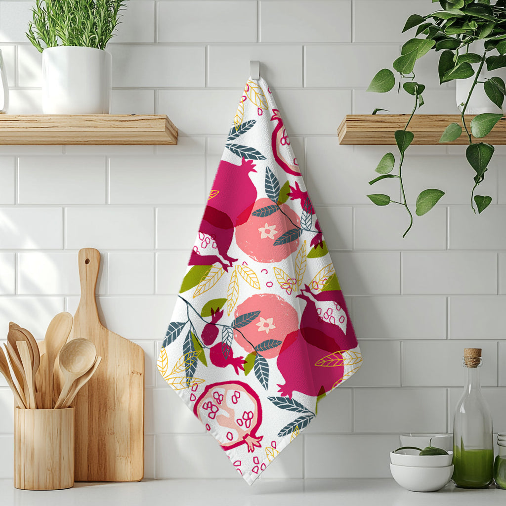 Decorative pomegranate tea towel with vibrant painted fruit design in a rustic kitchen setting