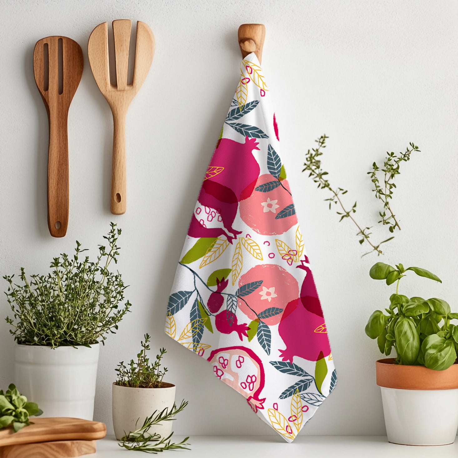 Pomegranate patterned kitchen towel featuring a hand painted style fruit design styled on a dining ta