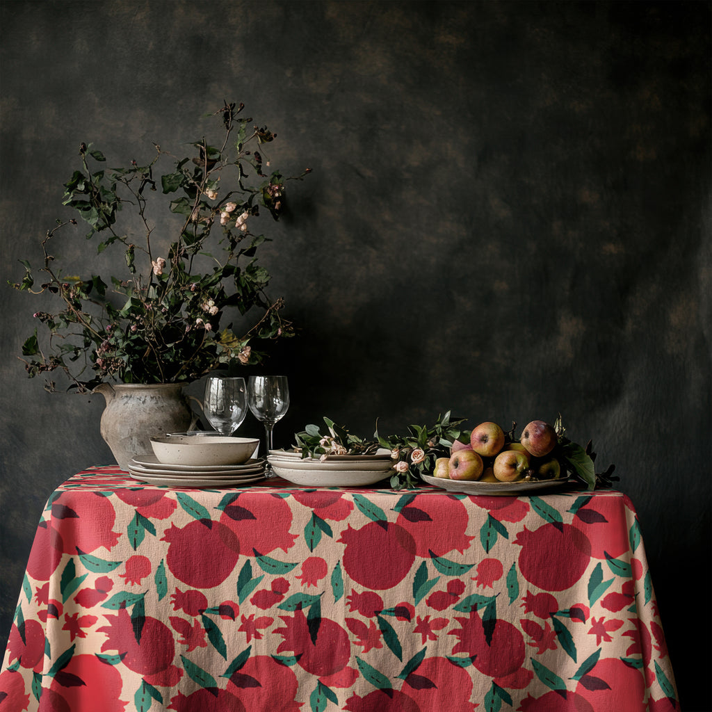 Pomegranate tablecloth styled on a dining table in a bright neutral interior showing Italian-inspired table decor