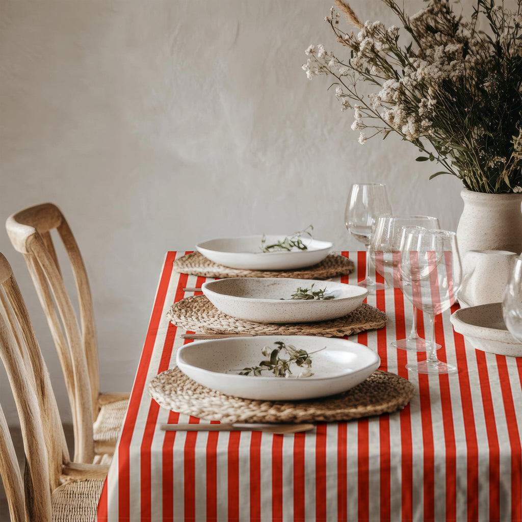 Red and white striped table linen styled with natural ceramics and greenery