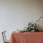 Red and white striped 100% cotton twill tablecloth styled for an elegant dining setting.