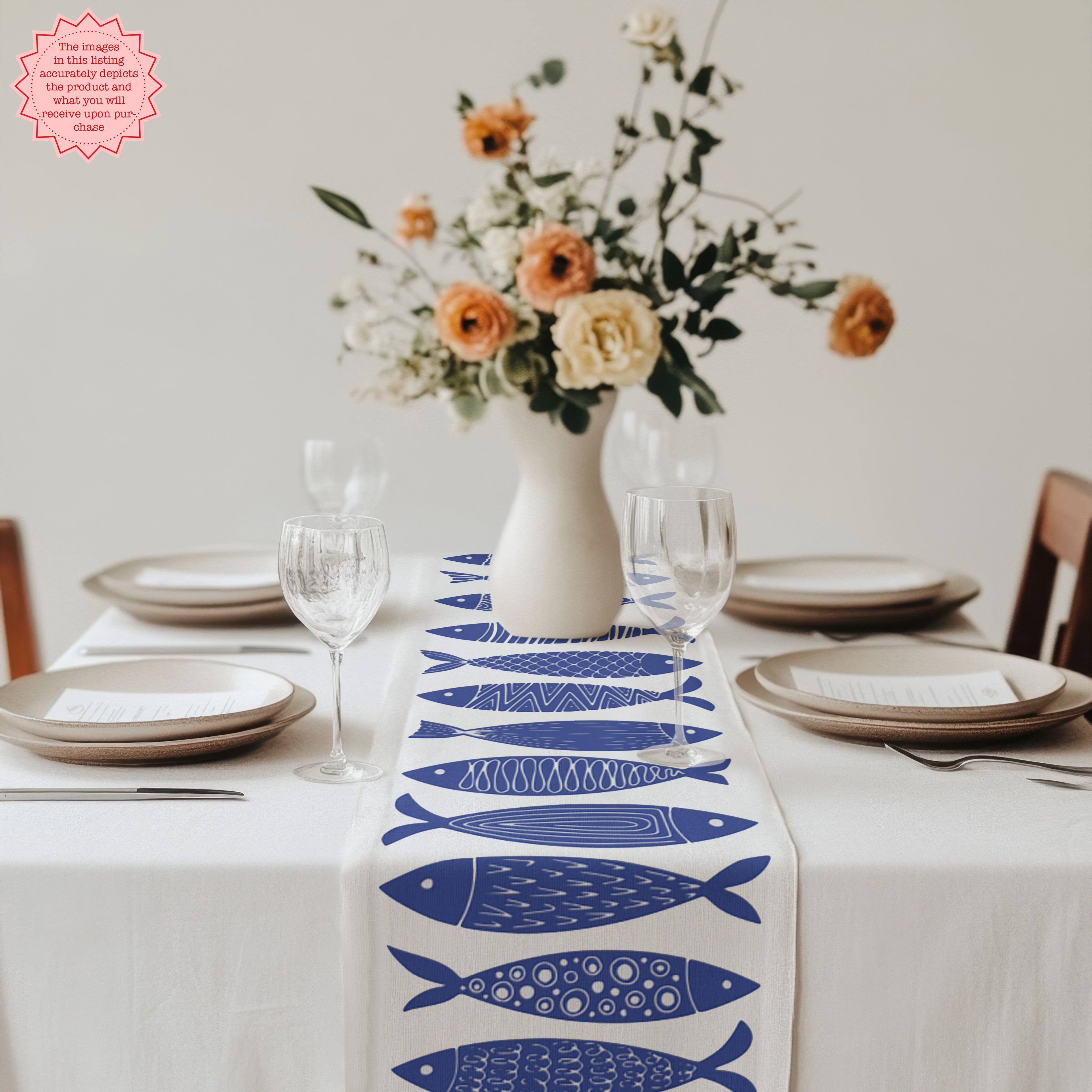 Blue folk art fish table runner in cotton fabric, creating a nautical and modern dining look.