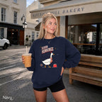 Navy Christmas sweatshirt featuring a funny “Season Honkings” goose wearing a Santa hat and red scarf with a Christmas gift.
