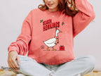 Festive Comfort Colors crewneck sweatshirt featuring a playful Christmas goose design with a Santa hat and red scarf.