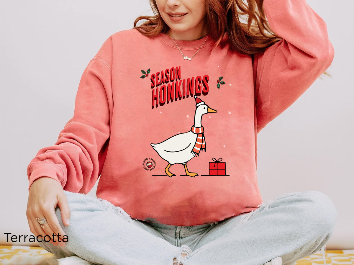 Festive Comfort Colors crewneck sweatshirt featuring a playful Christmas goose design with a Santa hat and red scarf.