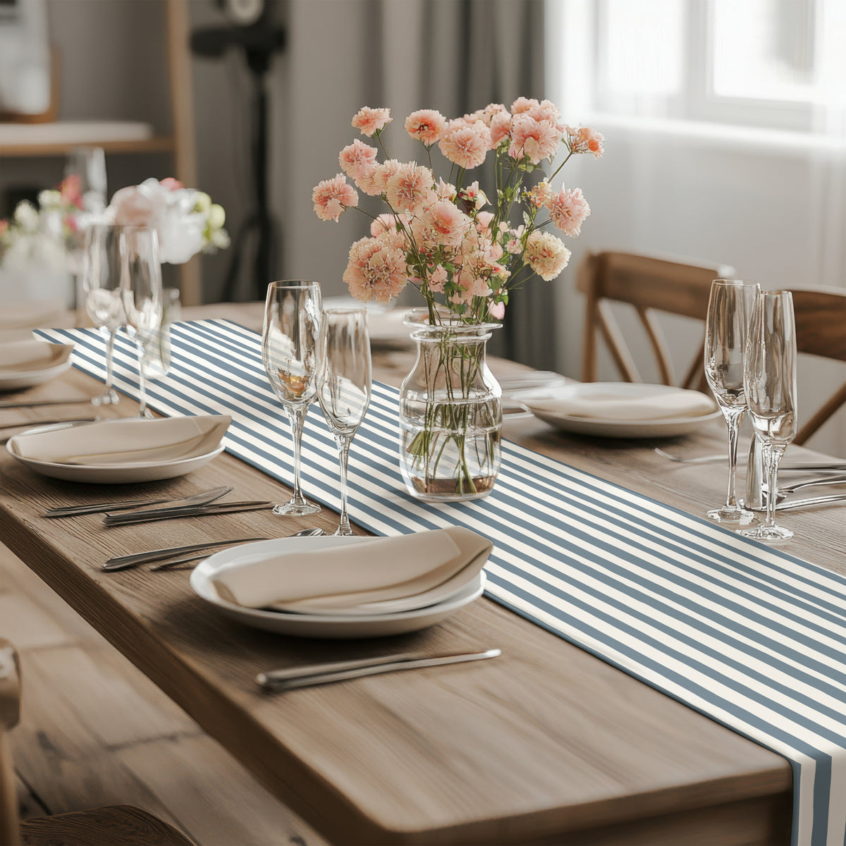 Modern dining table featuring a slate blue striped table runner with elegant white plates and wine glasses