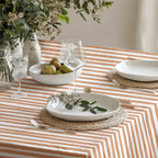 Close-up of the fine hand-drawn terracotta stripes on a soft cream cotton twill tablecloth.