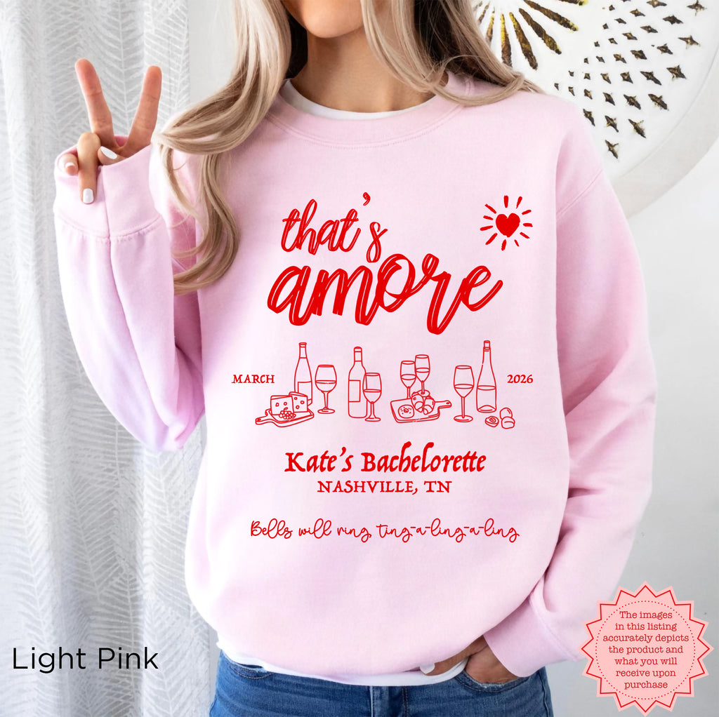 Custom ‘That’s Amore’ Bachelorette Sweatshirt in Light Pink, personalized with bride’s name, location, and year.