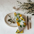Watercolor lemon cotton twill cloth napkin displayed on dining table with fresh citrus-inspired kitchen decor
