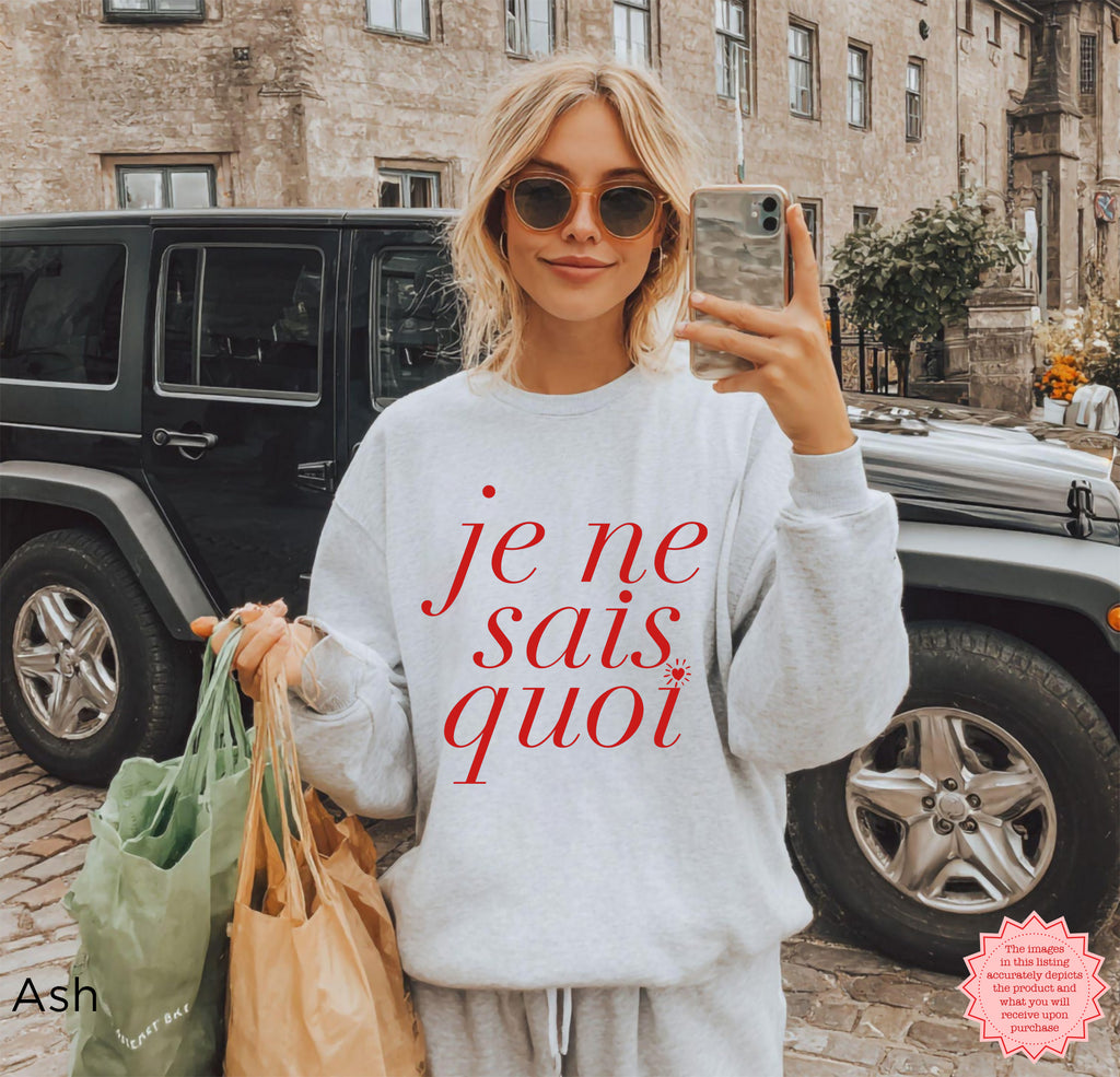 Woman wearing Je Ne Sais Quoi sweatshirt in ash grey, Parisian-inspired cozy travel outfit with tote bags
